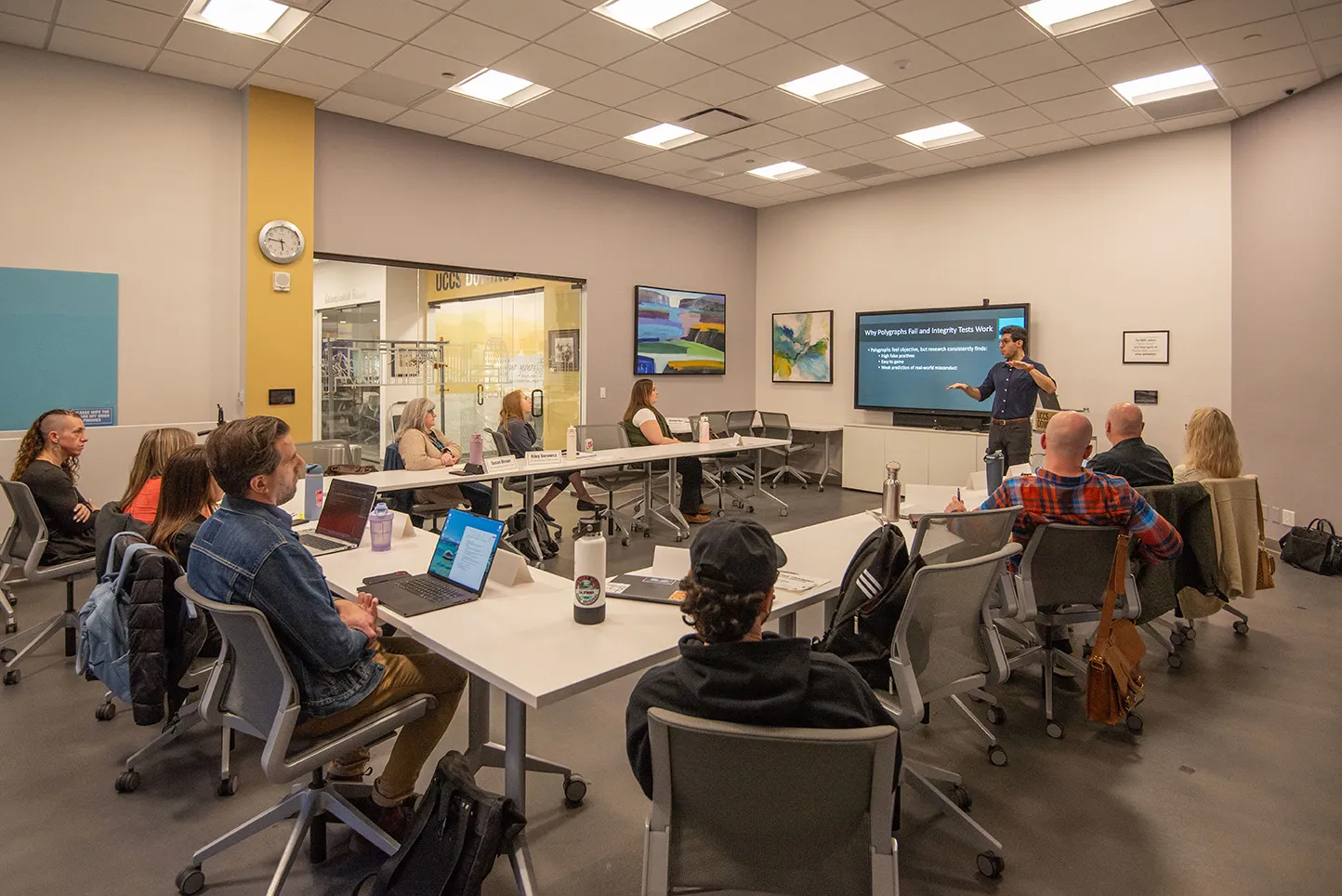 People sitting at desks watching a presentation.